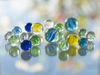 Colorful Glass Marbles on Reflective Surface.