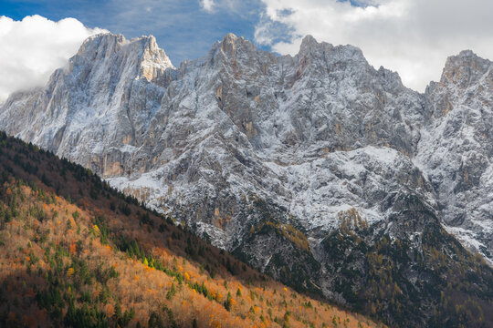 Aerial view of the majestic, snow-dusted peaks contrast sharply with the vibrant autumn colors of the lower slopes, Vr&Aring;&iexcl;i&Aring;&iexcl;ka cesta, Kranjska Gora, Slovenia.
