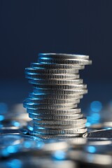 Fototapeta na wymiar Many stacked coins on table against blurred background, closeup