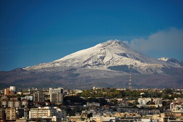 The smoking volcano Etna towers over Catania.