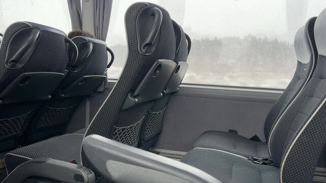 Intercity bus interior with empty passenger seats by window, winter road travel, public transport, sustainable mobility, eco travel concept.