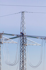 Fototapeta premium Technicians working on high voltage power lines atop transmission tower.