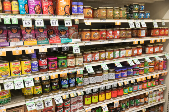 Grocery store shelves with sauces seasonings salsas and packaged food products