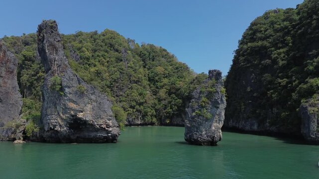 Sailing trips. Sailing yacht off Panak Island, yacht trip in Thailand. Drone view of a sailing catamaran off the coast of a limestone island.