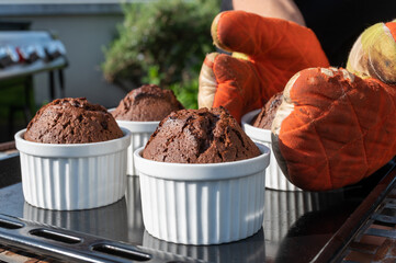 Frisch gebackene Schokoladenmuffins mit Backhandschuhen