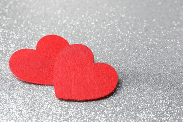 Obraz premium Love. Red decorative hearts on shiny gray background, closeup. Space for text