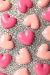 Obraz premium Love. Pink decorative hearts on shiny gray background, flat lay