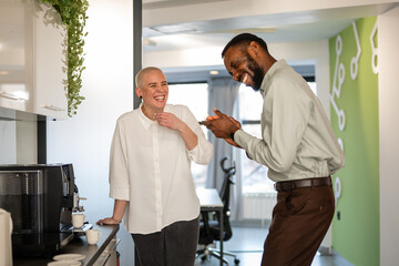 Diverse colleagues laughing during office coffee break