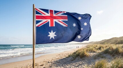Australian national flag waving proudly on a wooden pole against a bright sunny sky overlooking a beautiful sandy beach shoreline with gentle ocean waves approaching
