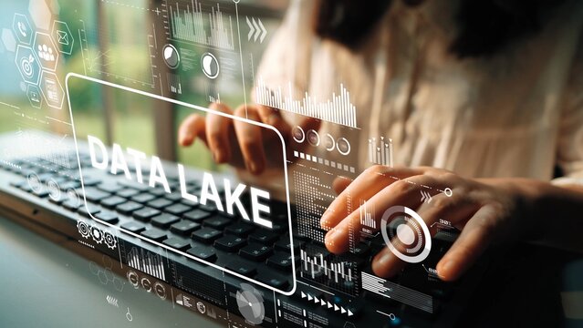 Close-up of hands typing on a keyboard with data visualization graphics depicting data lake concepts. Asymptotic smart data analytic.