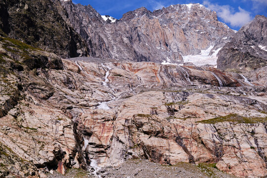 Waterfalls from a glacier falling down a rocky wall, Veny valley
