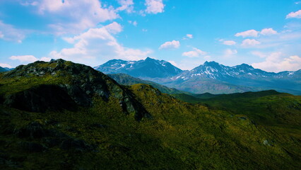 Obraz premium Breathtaking views of towering mountains surround verdant valleys. Bright sunshine illuminates the landscape, showcasing natures beauty in a serene summer setting.