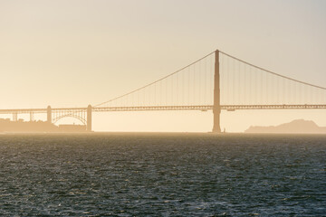 Golden Gate Bridge at sunset, with warm evening light illuminating the iconic structure. Scenic view of San Francisco&rsquo;s landmark spanning the bay, creating a dramatic and picturesque atmosphere