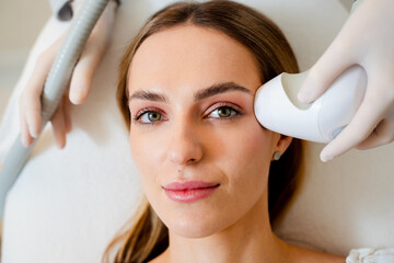 Fototapeta premium Hardware cosmetology needle-free RF facial lifting for non-invasive skin tightening.