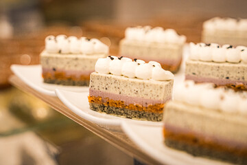 Assorted sweet pastries arranged on a serving tray, featuring a variety of desserts with creamy fillings and decorative toppings. Delicious baked treats presented for dessert, celebration, or caf&eacute; dis