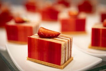 Assorted sweet pastries arranged on a serving tray, featuring a variety of desserts with creamy fillings and decorative toppings. Delicious baked treats presented for dessert, celebration, or caf&eacute; dis