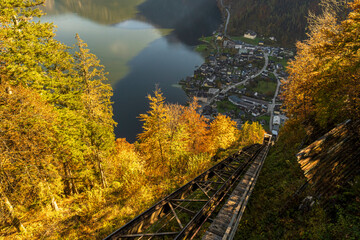 Obraz premium Autumn alpine village overlooking mountain lake with funicular railway