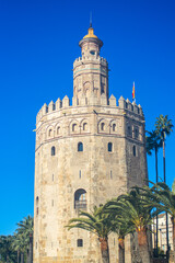 Fototapeta premium The iconic Golden Tower stands along the Guadalquivir River, reflecting centuries of maritime history in Sevilla, Spain.