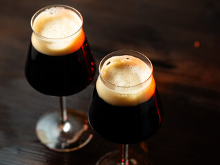 Two dark beers on a wooden table, top view. Stout beer