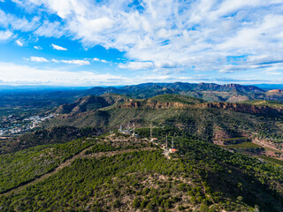 Obraz premium View of mountains and communication towers in a rural area during daytime with a clear sky and scattered clouds