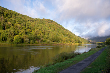 Fototapeta premium Silent morning on Moselle River near Ediger-Eller town, view of water and green hills, tourist destination in Germany