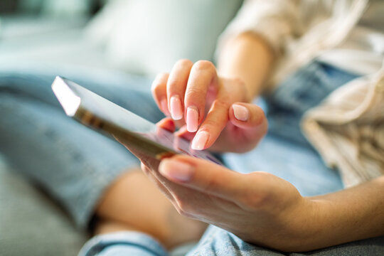 Young woman texting on smartphone at home