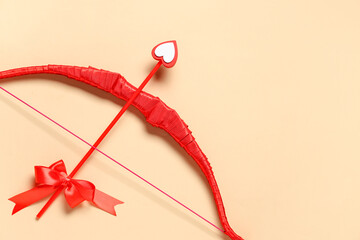 Naklejka premium Red cupid's bow on color background. Valentine's Day celebration