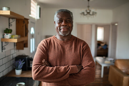 Confident senior man with arms crossed at home