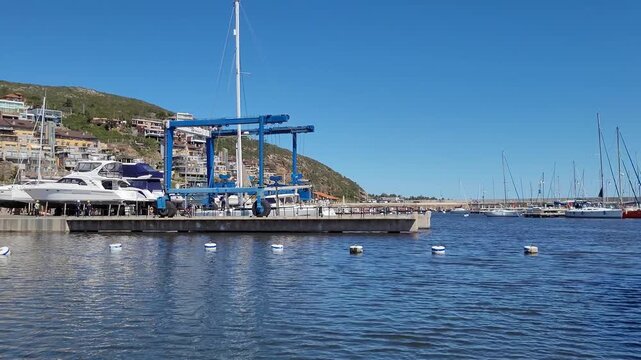 Industrial marine hoist lifting a vessel from the water for maintenance in a uruguayan shipyard