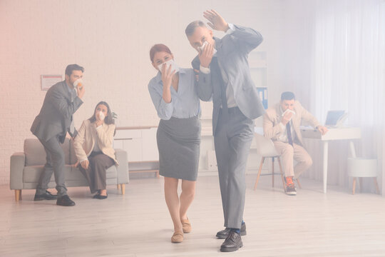 Business people covering faces with wet tissues in burning office building