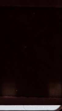 vertical 16mm film burn and light leak transition, seamless 4k vintage grain and scratch overlay on black background