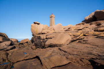 wideangle Landscape with Phare Mean Ruz Lighthouse on a sunny day. landmarks in Ploumanach, Brittany, France. travel destination, tourist attraction