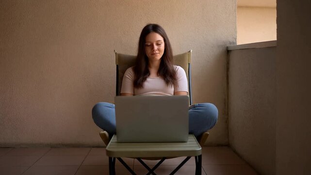Focused Woman at Green Table Typing on Laptop, Quiet Home Office, Intimate Close-Up View, in a Cozy Living Room