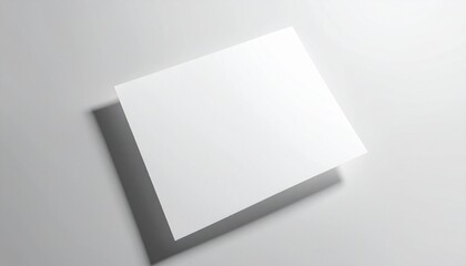 A blank white card with a shadow lies on a light gray surface viewed from above at an angle