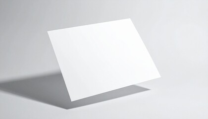 A blank white card stands upright casting a shadow on a plain white surface from a slightly elevated viewpoint