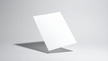 A blank white card standing upright on a plain surface viewed from the side