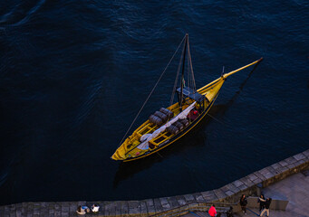 Fototapeta premium Small boat navigating dark blue water from a high angle.