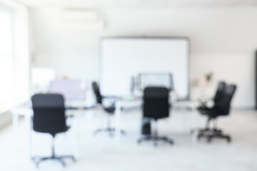 Blurred view of school computer lab with tables and projector screen