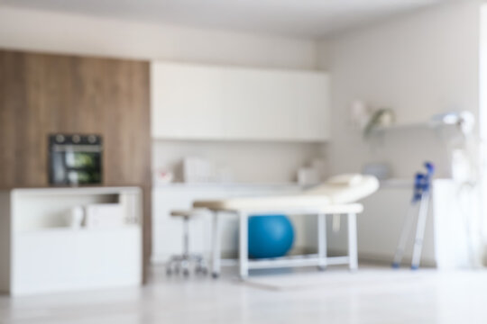 Blurred view of physiotherapist's office with couch and counters