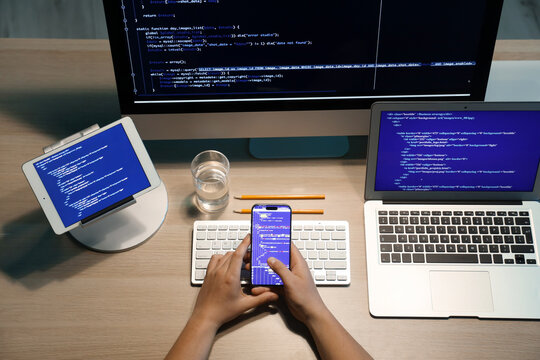 Male programmer working with mobile phone in office, closeup