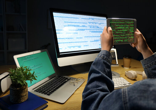 Male programmer working with modern tablet computer at table in office, closeup