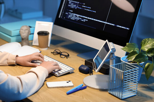 Female programmer working with computer at table in office, closeup