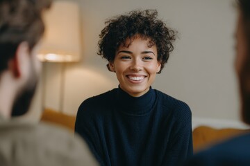 Engaged young woman with curly hair smiles genuinely while participating in a focused conversation