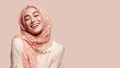 Young woman wearing a patterned headscarf expresses radiant happiness against a plain background