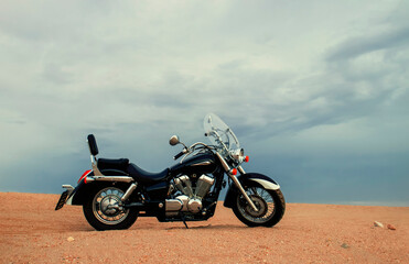 A motorcycle stands still beneath a vibrant sunset sky, capturing a powerful sense of freedom, adventure, and independence, symbolizing the thrill of open roads, and personal journeys