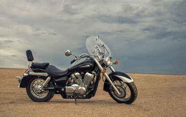 A motorcycle rests beneath a vibrant sunset sky, evoking freedom, adventure, and independence, symbolizing open roads, personal journeys, and the endless desire to explore new horizons.