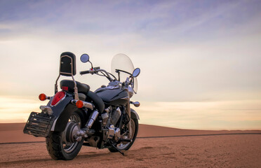 Naklejka premium A motorcycle rests beneath a vibrant sunset sky, evoking freedom, adventure, and independence, symbolizing open roads, personal journeys, and the endless desire to explore new horizons.