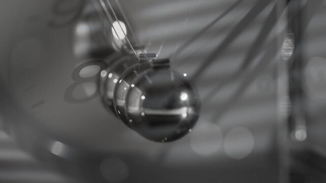 Close-up of a Newton&rsquo;s cradle with chaotic motion, symbolizing the passage of time and the interplay between order and chaos. The image emphasizes the movement and metallic texture, suitable for scien