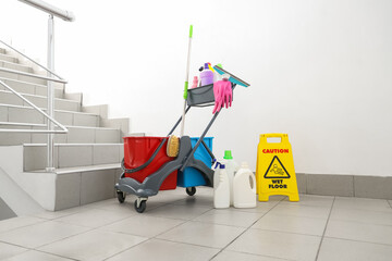 Trolley with cleaning supplies in stairway