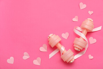 Fototapeta premium Composition with dumbbells, ribbon and paper hearts on pink background. Valentine's Day celebration